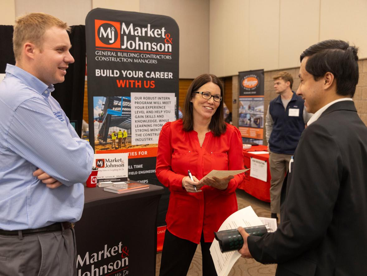 A student talks to prospective employers at a career fair.