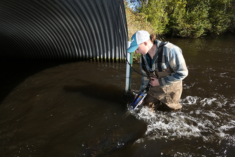 Heidi Lieffort, associate research specialist with CLRR, takes samples of water from Horse Creek in Star Prairie to check phosphorus and chlorophyll levels. The creek flows into Cedar Lake.