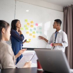 Team members planning a strategy using stikcy note on the board
