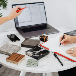 A hand pointing at a laptop display 