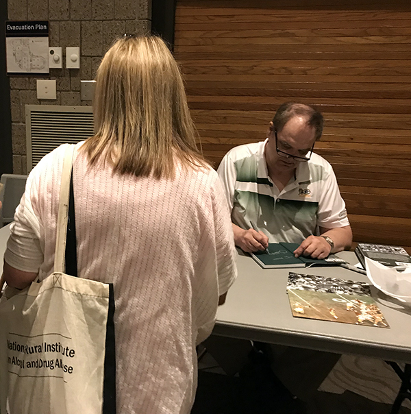 Chester Marcol signs copies of his book, “Alive and Kicking,” after speaking at UW-Stout at the 35th annual National Rural Institute on Alcohol and Drug Abuse.