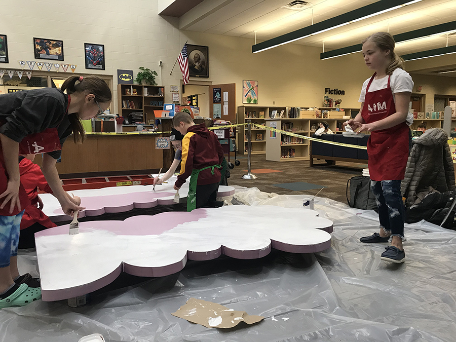 Oaklawn Elementary students help paint the mural clouds.