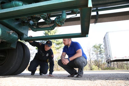 UW-Stout student Robert Wood, right, inspects a semitrailer with State Patrol inspector Ian Thompson at a weigh station on Interstate 94 near Menomonie. 