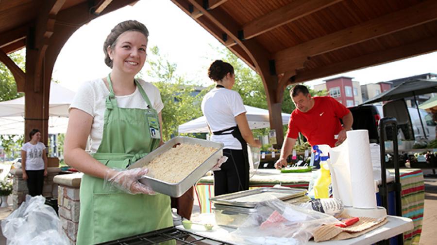 UW-Stout dietetics student Amanda Nass offers zucchini dessert squares at the Veggin’ Out booth at the Downtown Farmers’ Market in Eau Claire.