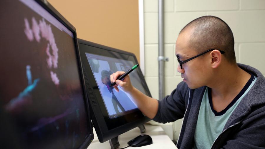 Hue Vang works in a School of Art and Design lab.