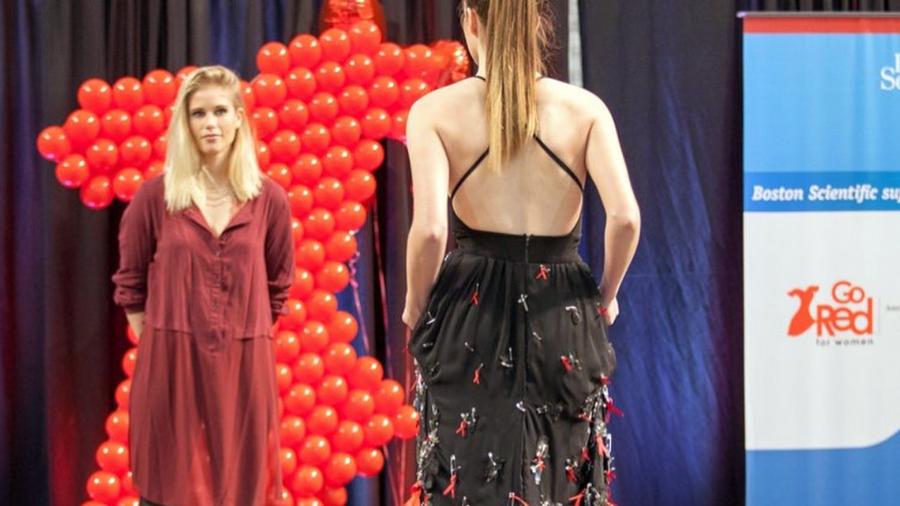 Carly Troudt watches as her dress is modeled by Ferrel Rome at the Hearts for Fashion Show at the Mall of America.