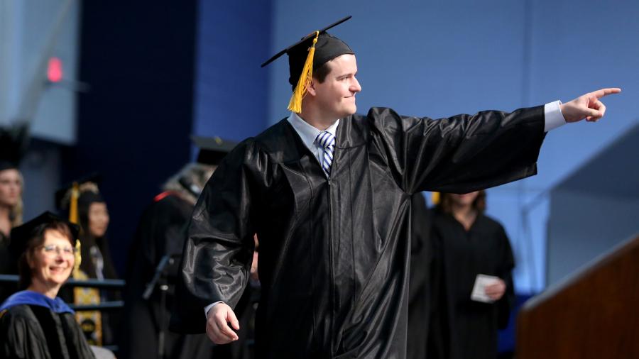 Nick Super celebrates during his walk across the Johnson Fieldhouse stage to receive his diploma.