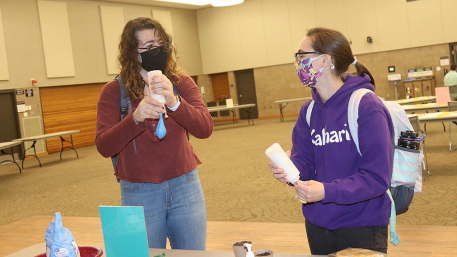 UW-Stout students Amara Miller, at left, and Tori Williams craft a stress ball out of a balloon recently.