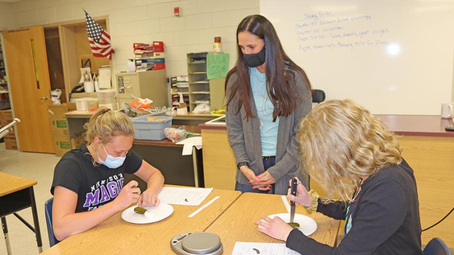 Kelley, in center, with students working on a pickle autopsy, which is part of a health class that gives students technical college credit.