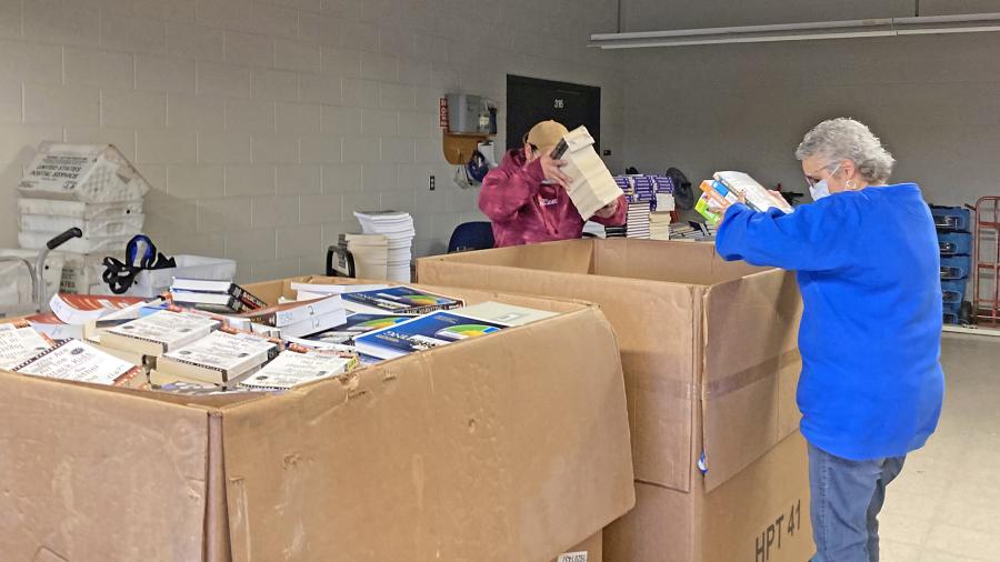 Kim Uetz, IRC acquisitions specialist, helps load books into boxes. /UW-Stout photo by Pam Powers
