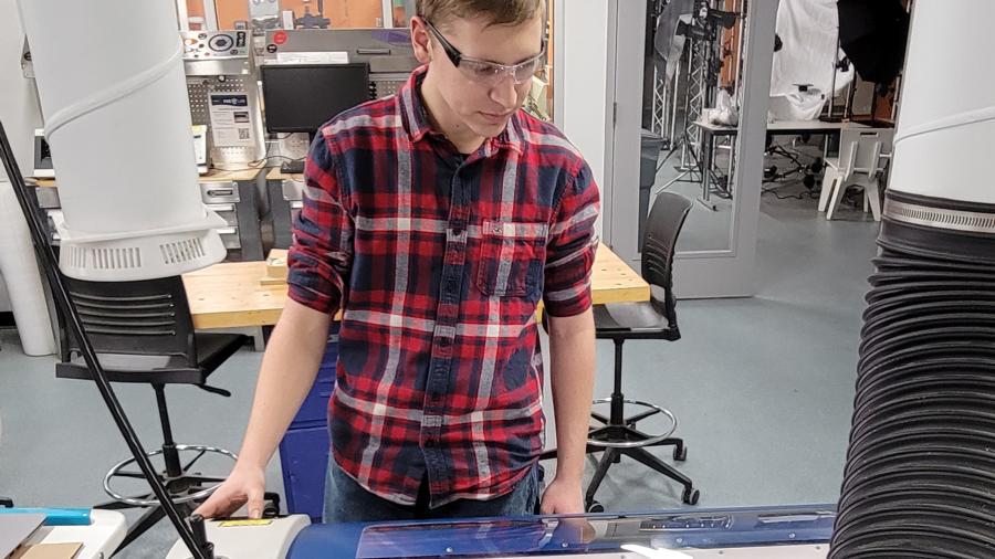 Thomas Shamla, a first-year UW-Stout student in mechanical engineering, operates a laser cutter and engraver in the Discovery Center Fab Lab as part of his Grow, Persist and Succeed campus job.