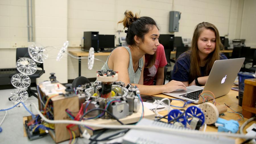 Students work on a flexible robotic arm in a lab at UW-Stout’s Fryklund Hall, home to the Robert F. Cervenka School of Engineering.