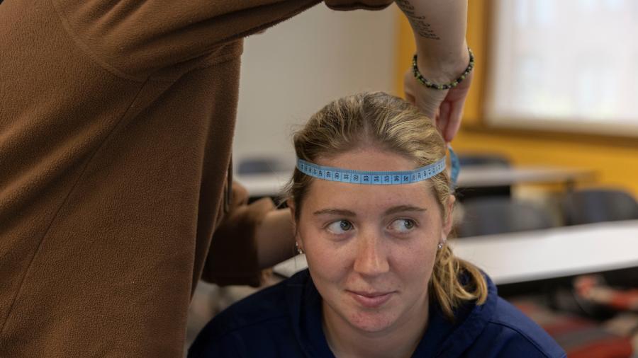 Psychology students measure the circumference of each other's heads