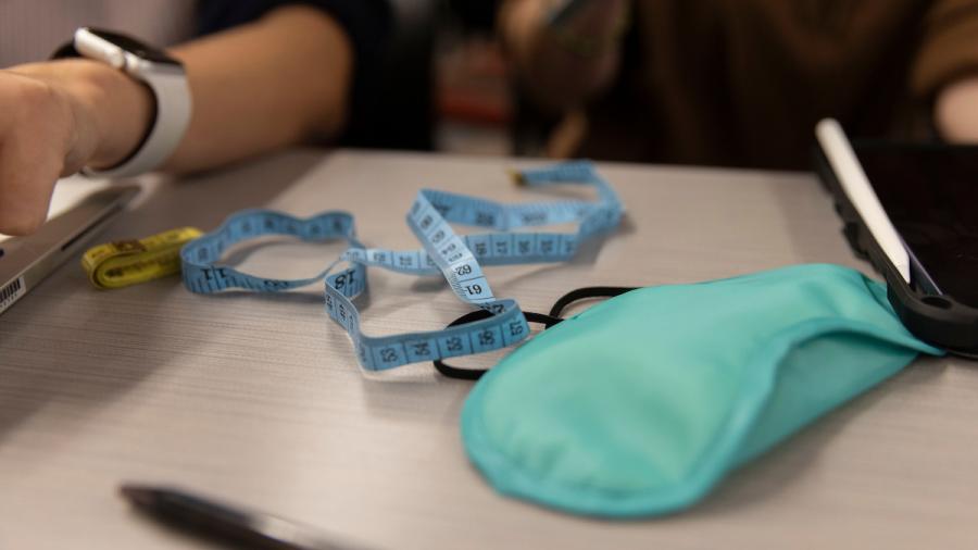 A measuring tape, caliper and blindfold on a table