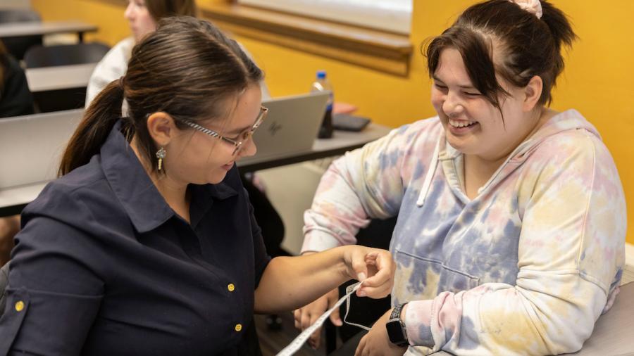 Psychology students examine lengths on a measuring tape