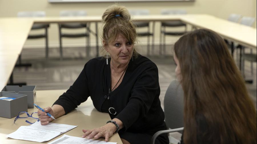 Barb Bauer, technology education program director, talks with a high school student during Teach Day.