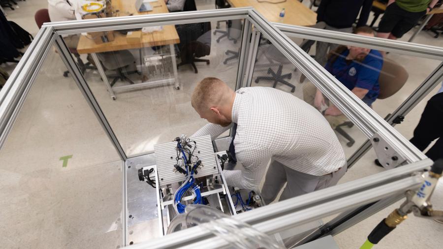 Mack Klafter works on the nVent robotic hinge assembly machine.