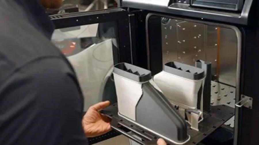 Student removes 3D printed model from machine.