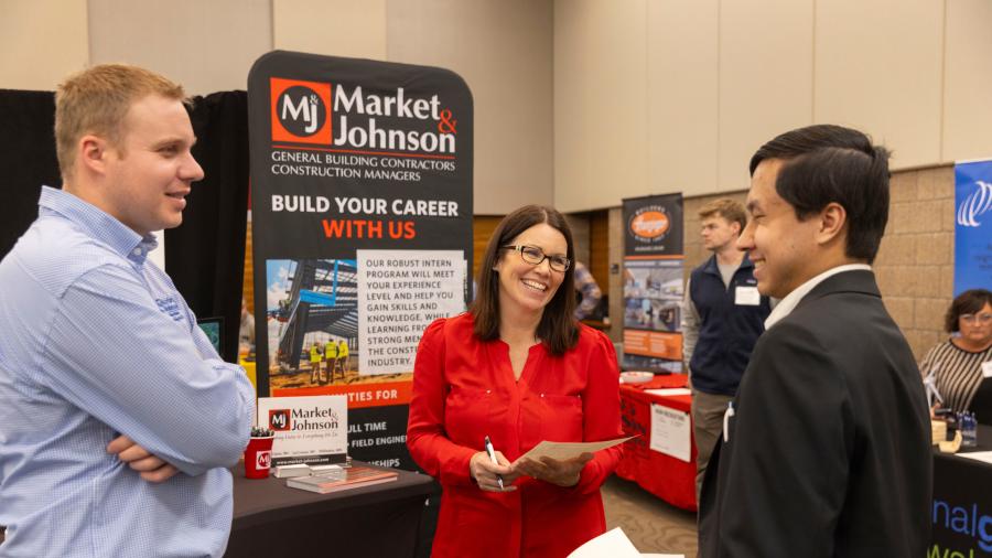 A UW-Stout student visits with recruiters from Market & Johnson construction company of Eau Claire during the 2024 spring Career Conference.