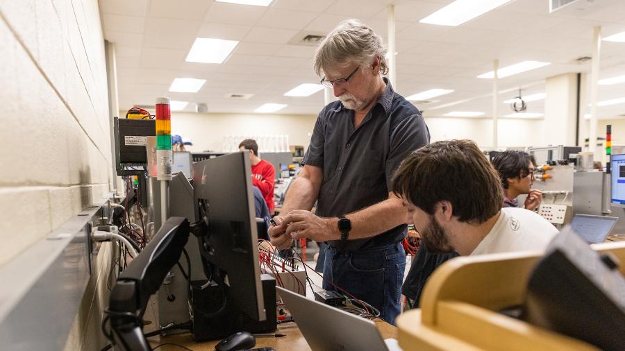 Paul Craig, program director and recipient of a Fulton and Edna Holtby Manufacturing Engineering Chair award, works with students in an engineering lab.
