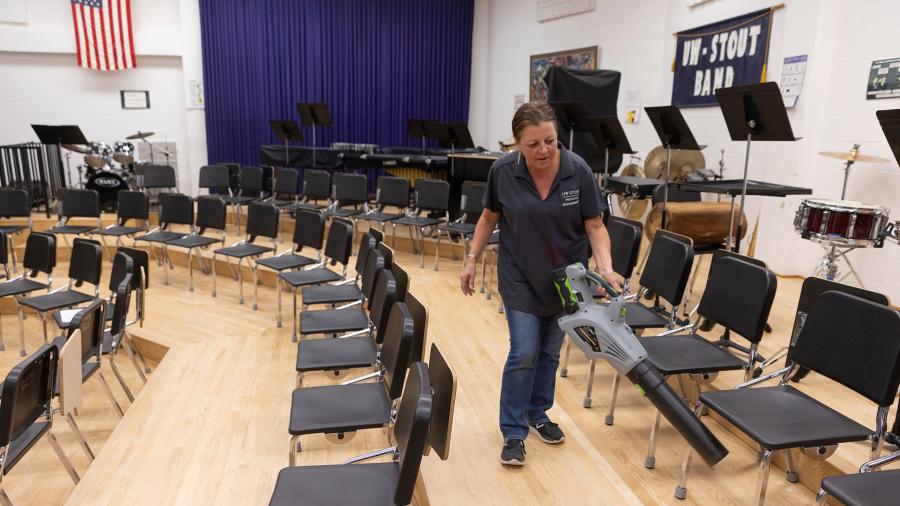 Sara Moltzan, a member of the UW-Stout academic custodial staff, uses a leaf blower while cleaning the band room in the Applied Arts Building.