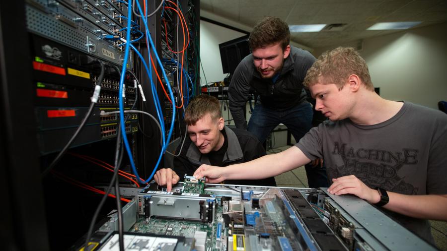 UW-Stout students work on a computer server in a lab.
