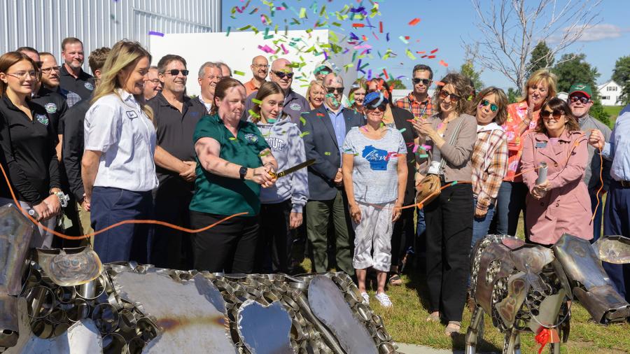 Officials from Ellsworth Cooperative Creamery and UW-Stout celebrate the completion of cow sculptures at the new Menomonie plant with a twine-cutting.