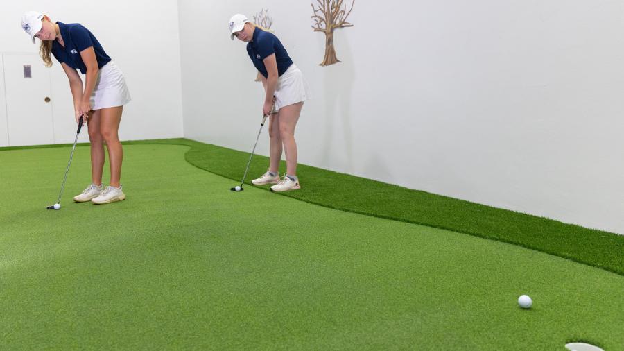 Members of the UW-Stout women’s golf team practice on the putting green.