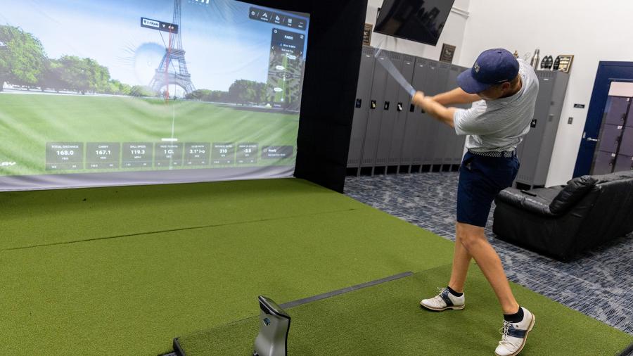 A member of the UW-Stout men’s golf team uses one of the two golf simulators at the center.