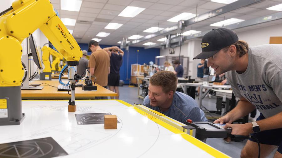 Students programming a robotic arm in the Robotics Lab