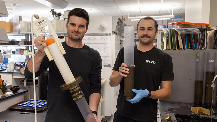 CLRR Field Coordinator Andrew Schneyer, left, and Laboratory Coordinator Conor Dougherty show a gravity coring device like the one used to take sediment cores on Green Lake in Wisconsin. Conor is holding an intact sediment core.