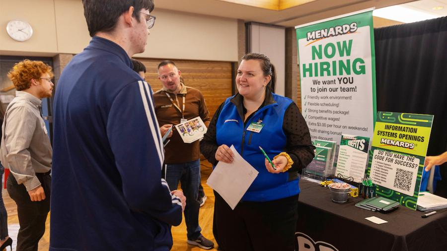 Menards recruiters talking with a students at the Career Conference