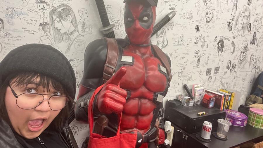 Erika Saindon and a statue of the character Deadpool.