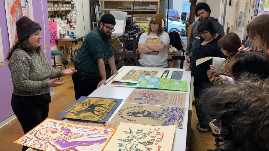 Colorful screen prints laid out on a table to display.