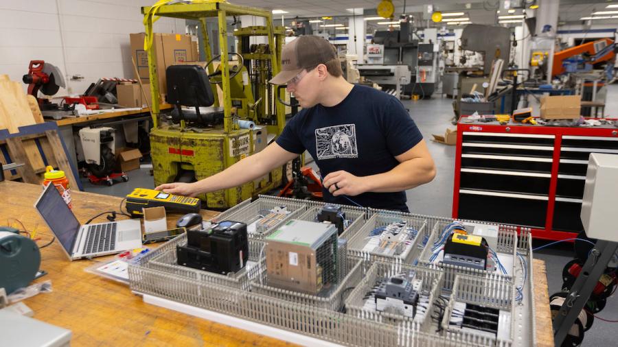 Luke Mertens works on the controls for the pallet stacker prototype