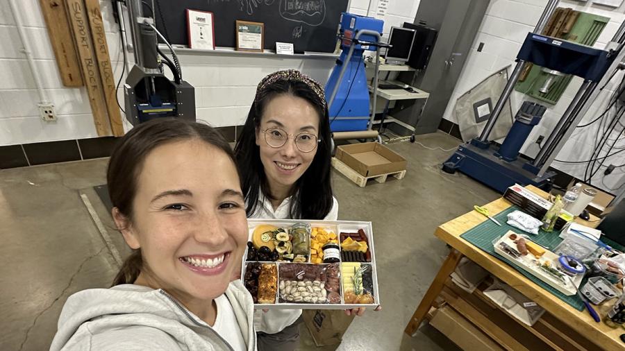 Two women pose with charcuterie