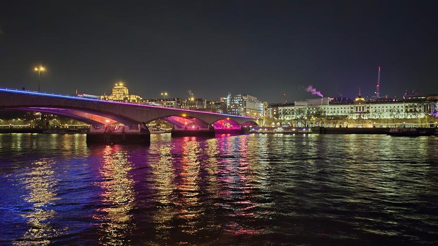Waterloo Bridge and the National Theatre are illuminated at night and reflected in the River Thames in London