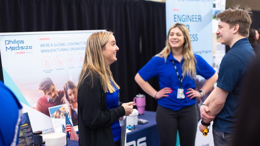 Students talk with employer recruiters at a career conference