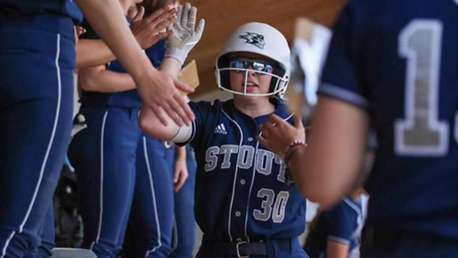 Softball teammates give high fives in the dugout
