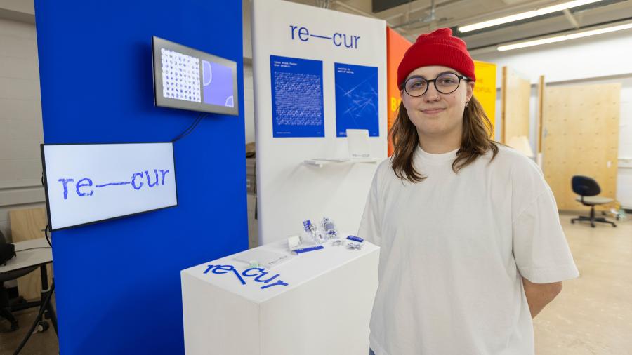 Woman stands with graphic design work