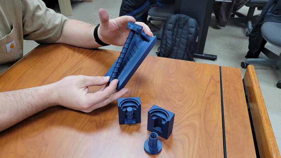 Aden Story hold 3D-printed thumbscrews for toolless furniture assembly.