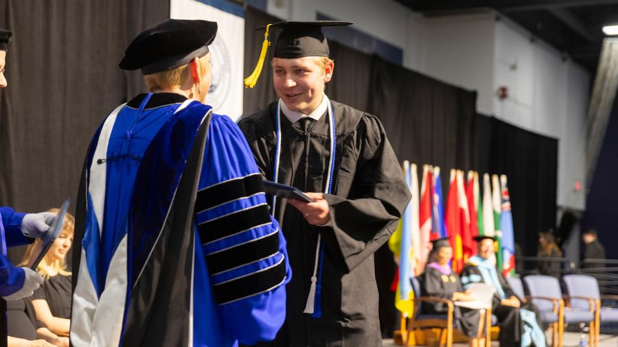 People shake hands at commencement