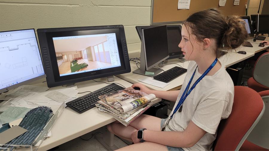 A student in the interior design camp uses software to create a living room space.