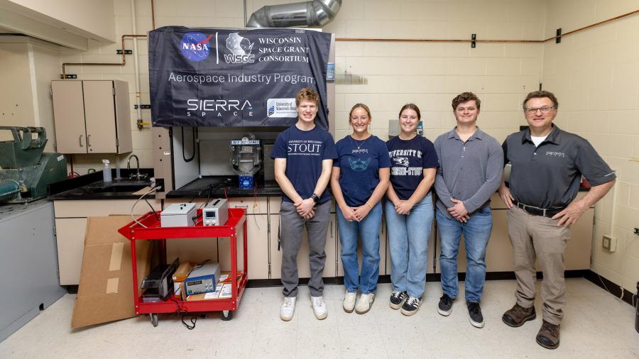 Five people pose in lab