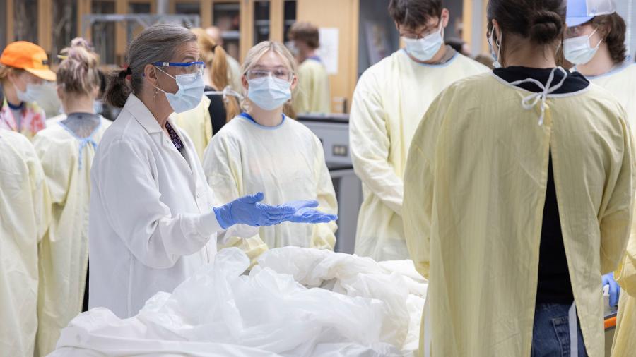 People in medical gear around table