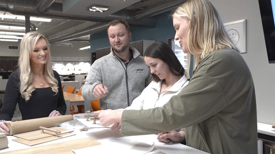 Four people look at furniture components