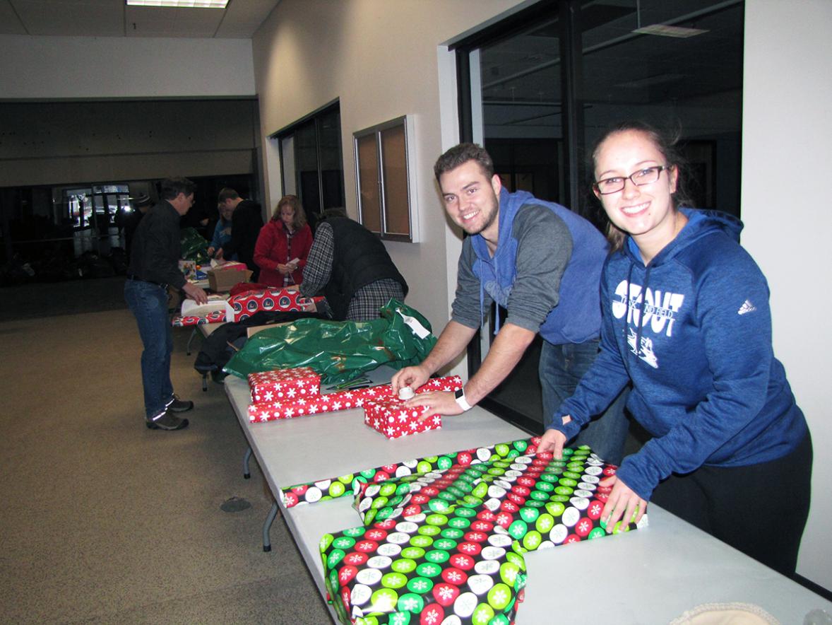UW-Stout students Walker Olson, at left, and Andrea Bertram volunteered to wrap gifts on Dec. 1 for the Road to Freedom’s Motorcycle Rights Organization’s Christmas Miracle that helps area children in need get needed items and toys for Christmas./UW-Stout photos by Pam Powers
