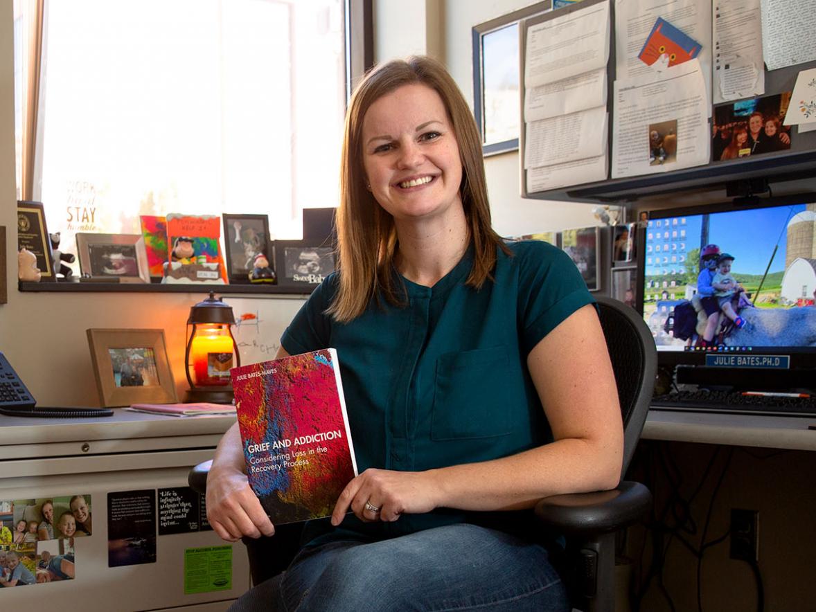 Associate professor Julie Bates-Maves with her newly published book "Grief and Addiction".