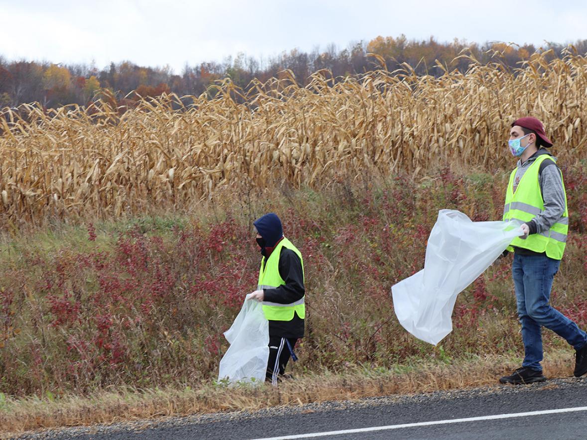 UW-Stout students Brenon Burkhardt, at left, and Gavin Raph pick up trash along Highway 72 near Downsville as part of a community service project with the Marketing and Business Education Association.