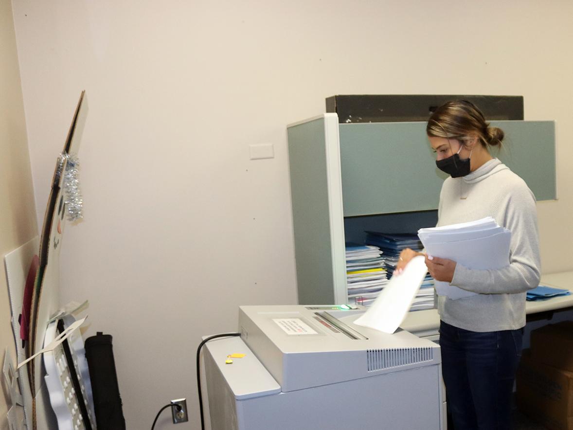 UW-Stout student Heather Kent, a senior business administration major from Altoona, shreds office paper in the Human Resources office.